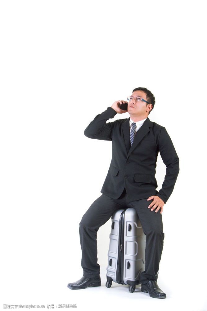 坐在箱子上的打电话商务男人图片